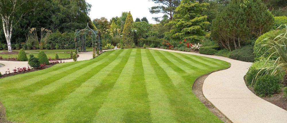 Striped,Lawn,With,Trees,,Paths,And,Arch,In,Large,Garden.